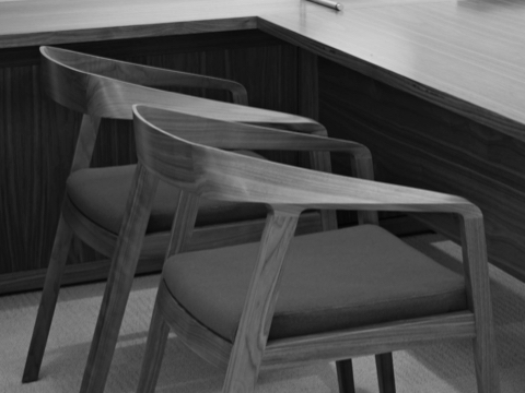 Black-and-white image of two Full Twist Guest Chairs positioned next to an L-shaped work surface.