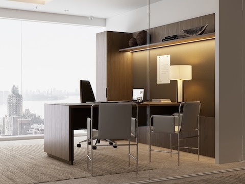 A Geiger One Private Office in Natural Flat Cut Walnut with a Clamshell Office Chair and Envelope Guest Chairs viewed from an angle.