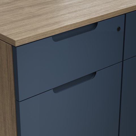 Detail shot of the Geiger One Casegoods partial painted flush pull option on a Natural Flat Cut Walnut drawer front viewed from an angle.