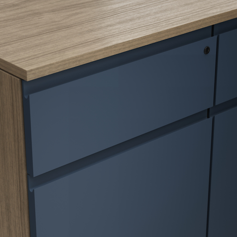 Detail shot of the Geiger One Casegoods solid painted flush pull option on a Natural Flat Cut Walnut drawer front viewed from an angle.