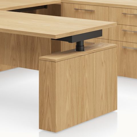 Detail shot of the Geiger One Casegoods leg surround leg option in Natural Flat Cut Oak.