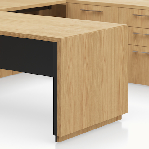 Detail shot of the Geiger One Casegoods cascade leg option in Natural Flat Cut Oak.