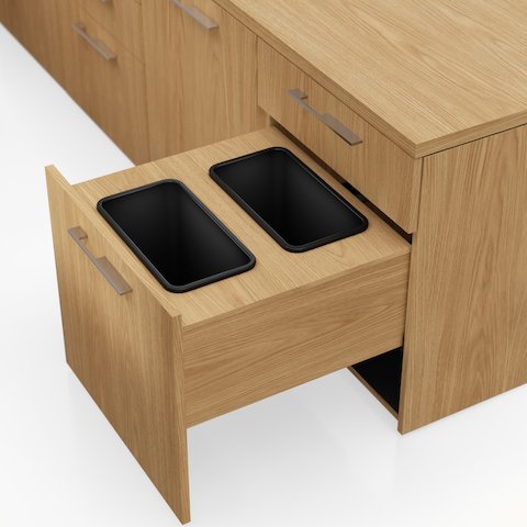 Detail shot of the Geiger One Casegoods waste drawer in Natural Flat Cut Oak viewed from an angle.