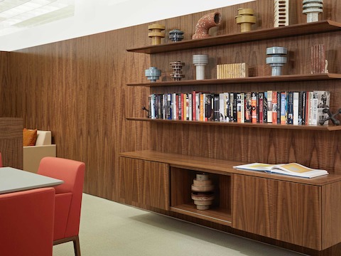 A Geiger Shelf System in a medium wood finish includes a base cabinet and three open shelves holding books and objects.