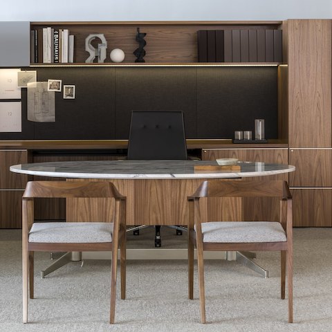 A private office furnished with the Geiger Shelf System, a stone-top MP Height-Adjustable Table, a Geiger Sotto Chair, and two Full Twist Guest Chairs.