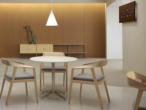An interaction space with a four-unit H Frame Storage credenza against the back wall and three Full Twist Guest Chairs around a table in the foreground.
