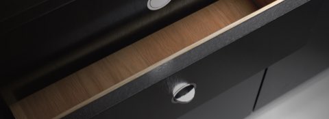 Close-up of a flush-mounted Flip pull in the partially open drawer of an H Frame Storage credenza.