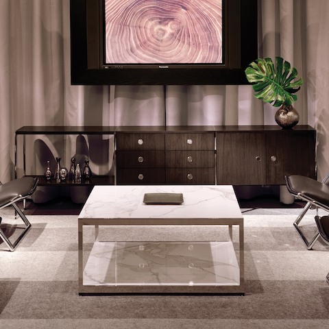 A lounge area featuring an H Frame coffee table with stone surfaces and a coordinating H Frame credenza.