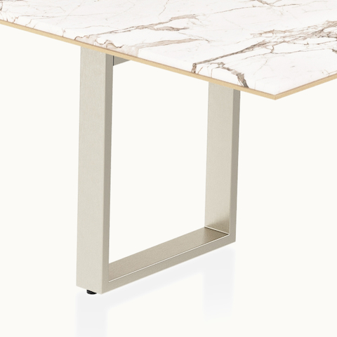 Highline Conference Table by DatesWeiser in Calacatta Gold Stone with leather edge detail and Satin Nickel base viewed from a 45 degree angle.