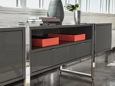 Highline Credenza by DatesWeiser with Umbra Grey Case and Polished Chrome Base in an office setting, angled view.