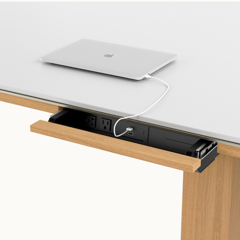 Detail shot of open power drawer on Highline Fifty Conference Table by DatesWeiser in Glacier White Corian and Natural Rift Cut Oak viewed from an angle.