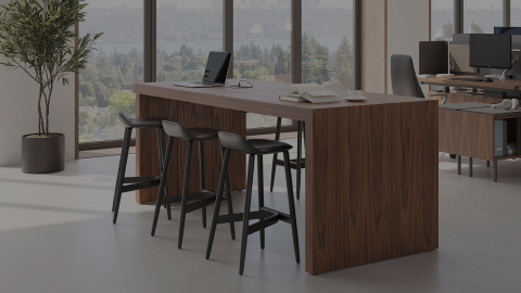 JD Waterfall Table by DatesWeiser in Walnut alongside Geiger One Open Plan workstations with Crosshatch Stools and Taper Chairs.