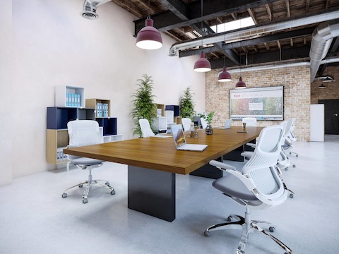 JD Conference Table by DatesWeiser surrounded by chairs in a conference room setting, angled view.