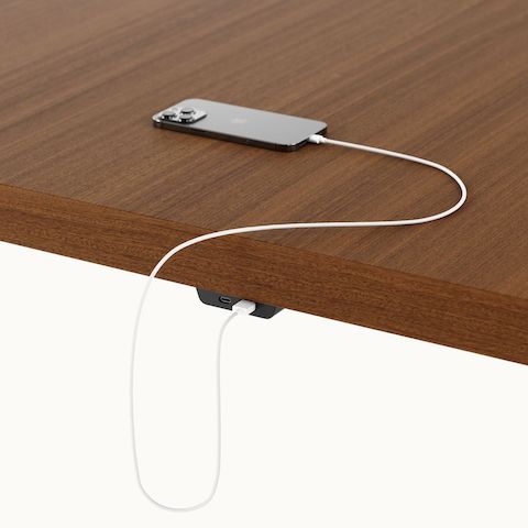 Detail shot of undermount power access on a rectangular JD Conference Table by DatesWeiser with a Natural Quarter Cut Walnut tabletop and Black base.