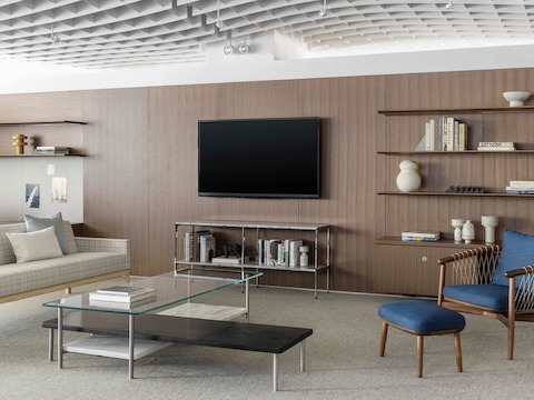 A collaborative lounge furnished with an L-shaped Layer coffee table, plaid Wood Base Lounge Seating, and a blue Crosshatch Chair and Ottoman.