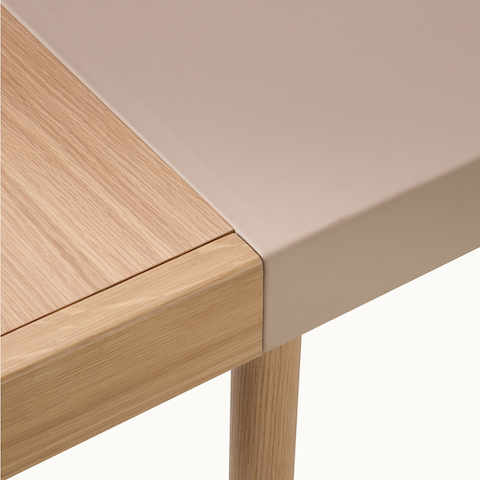 Detail showing the seamless blending of leather, solid wood, and veneer on a Leatherwrap Sit-to-Stand Desk in oak and Champagne leather.