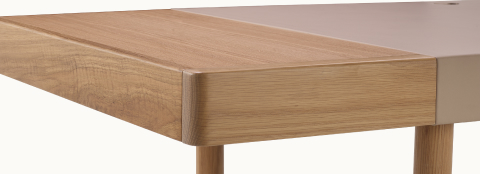 Close-up view of a Leatherwrap Sit-to-Stand Desk in oak and champagne leather showing the seamless blending of Leather, Solid Wood, and Veneer.