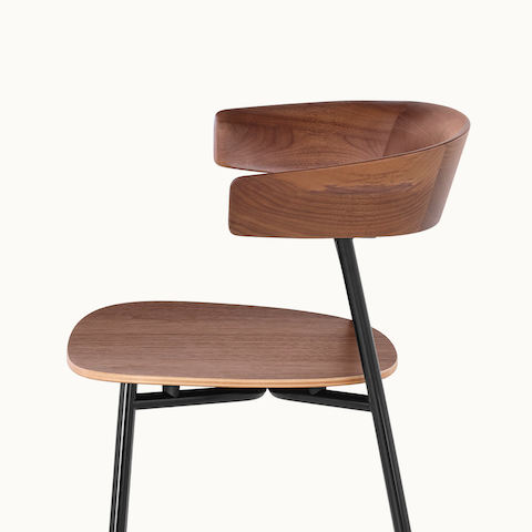 Side view of a Leeway Stool, showing the crescent-shaped, cantilevered backrest with a medium wood finish.