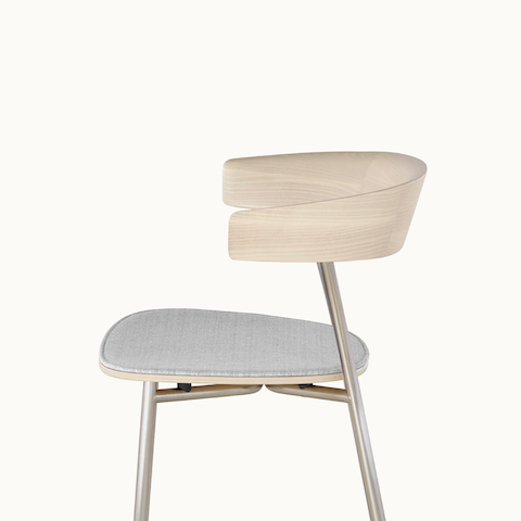 Side view of a Leeway Stool, showing the crescent-shaped, cantilevered backrest with a light wood finish.
