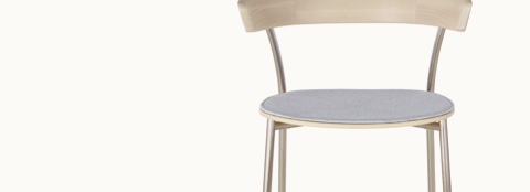 Front view of the upper portion of a Leeway Stool, showing a curved wood backrest with a light finish and a wood seat upholstered in light gray fabric.