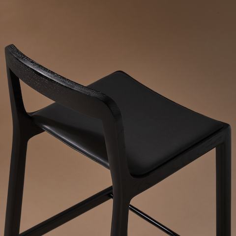 Lijn Stool by Carole Baijings for Geiger in Ebonized Oak frame upholstered with Maharam Prone Leather in Obsidian, detail shot on a neutral background.