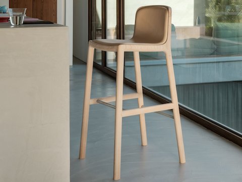 Lijn Stool designed by Carole Baijings for Geiger with leather upholstered seat and back on a matte wood frame viewed at an angle in a styled environment. Lijn Stool designed by Carole Baijings for Geiger with leather upholstered seat and back on a matte wood frame viewed at an angle in a styled environment.