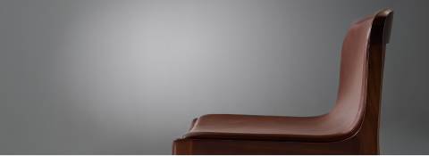 Lijn Stool by Carole Baijings for Geiger in Persian Walnut frame upholstered with Maharam Hue Leather in Bittersweet, detail shot on a grey background.