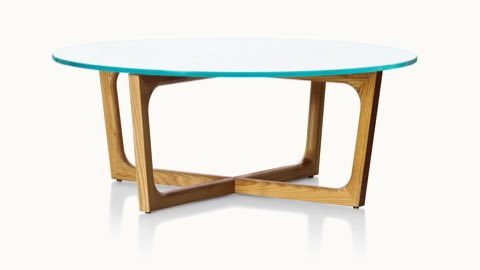 A round Loophole coffee table with a glass top and a wood base in a medium finish.