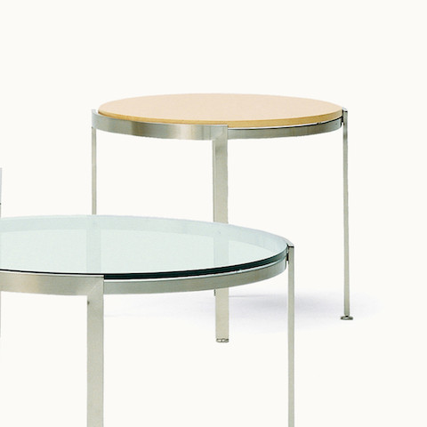 A round Metal Series side table with a wood top in the background and a round Metal Series coffee table in the foreground.
