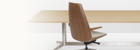 Partial view of a rectangular MP Conference Table with a high-back Clamshell Lounge Chair.