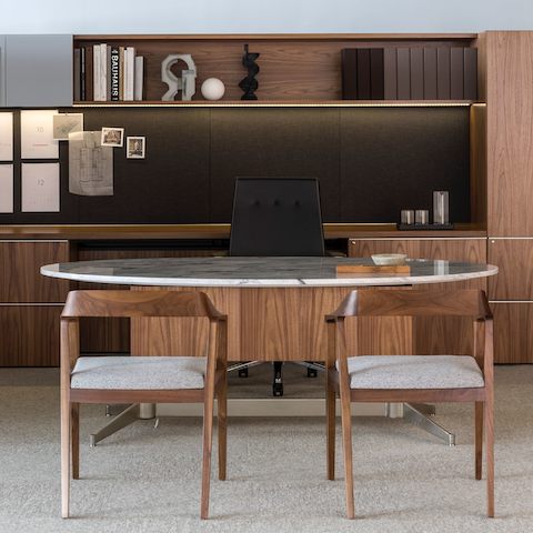 An executive office featuring an oval MP Height-Adjustable Table with a stone top used as a desk.