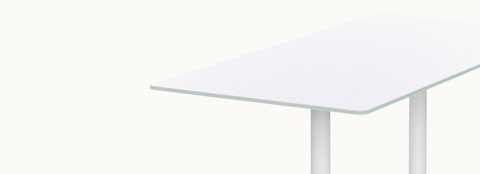 Partial angled view of a rectangular MP Table with a white back-painted glass top.