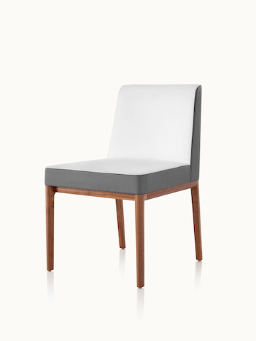 Angled view of an armless Nessel side chair with two-tone upholstery in off-white and gray.