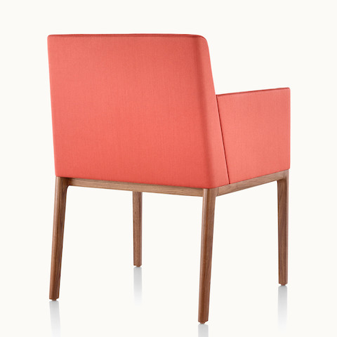 A red Nessel side chair with wraparound arms, viewed from behind at an angle to show how the upholstery aligns flush with the frame.