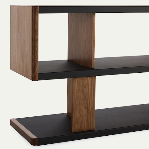 Detail shot of New Canaan Low Bookshelf designed by BassamFellows for Geiger in Walnut with Black Leather shown angled on a white sweep.