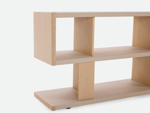 Detail shot of New Canaan Low Bookshelf designed by BassamFellows for Geiger in Oak with Champagne Leather shown angled on a white sweep.