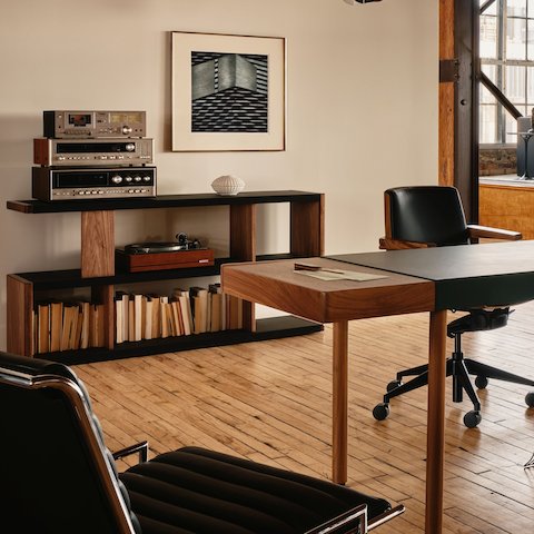New Canaan Low Bookshelf and Leatherwrap Sit-to-Stand Desk designed by BassamFellows for Geiger in Walnut with Black and Green Leather shown in a residential setting.