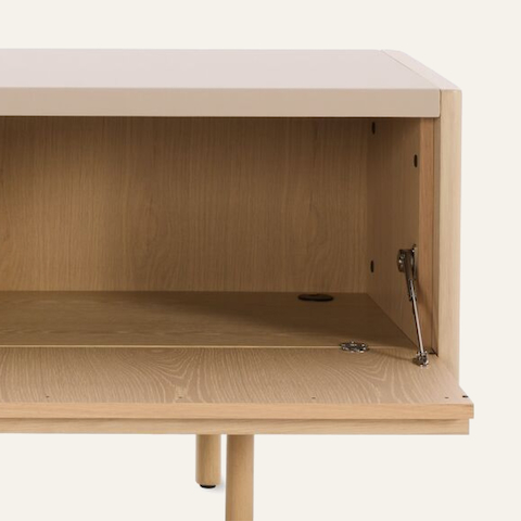 New Canaan Media Unit designed by BassamFellows for Geiger in Oak with Champagne Leather with open cabinet door in front view on a white sweep.