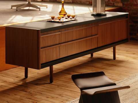 New Canaan Media Unit designed by BassamFellows for Geiger in Walnut with Black Leather shown angled in a residential setting.