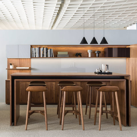 An open communal space featuring a rectangular Peer Table and six Crosshatch Stools to support impromptu gatherings.