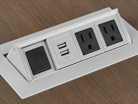 Close-up of a power module embedded into the surface of a Peer Table, showing power and data connections.