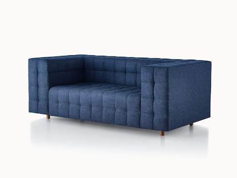 A two-seat Rapport Sofa in a deep navy colored textile, viewed at an angle.