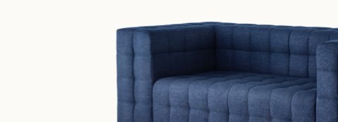 A two-seat Rapport Sofa in a deep navy colored textile, viewed at an angle.