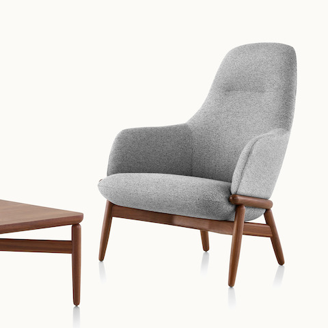 A Reframe occasional table next to a coordinating high-back Reframe lounge chair with gray upholstery.
