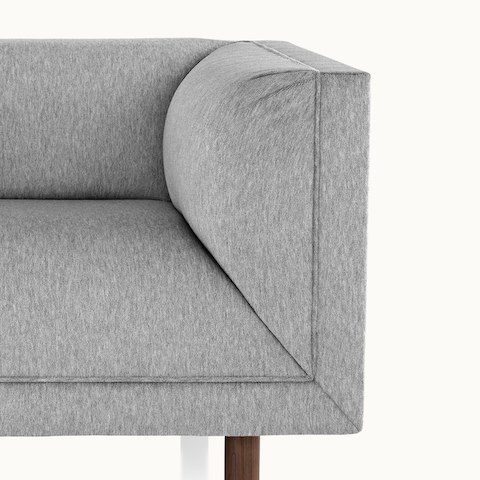 Partial view of a light gray club chair from the Rolled Arm Sofa Group, showing a padded armrest.