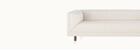 Partial front view of an off-white sofa from the Rolled Arm Sofa Group, showing a thickly padded arm, seat, and back.