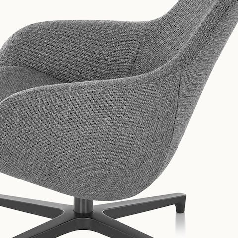 Partial side view of a Saiba Lounge Chair with gray upholstery, showing the impeccable tailoring.