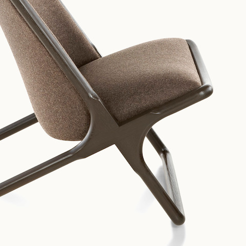 Partial side view of a Scissor lounge chair with brown fabric upholstery, focusing on the wood frame.