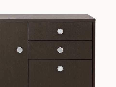 Partial view of a Sled Base Storage unit with a dark wood finish, showing four flush-mounted Flip pulls.
