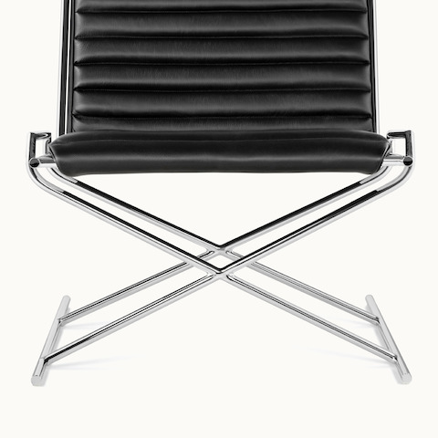 Partial front view of a Sled lounge chair, focusing on the X-shaped tubular steel frame.